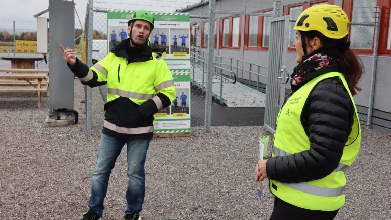 Kvinna på studiebesök i Byggbranschens Säkerhetspark lyssnar till introduktion av studiebesöket.