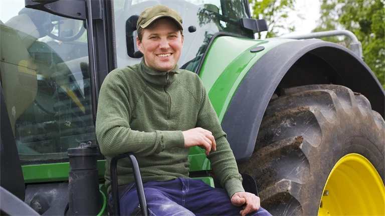 Man sitter på en traktor
